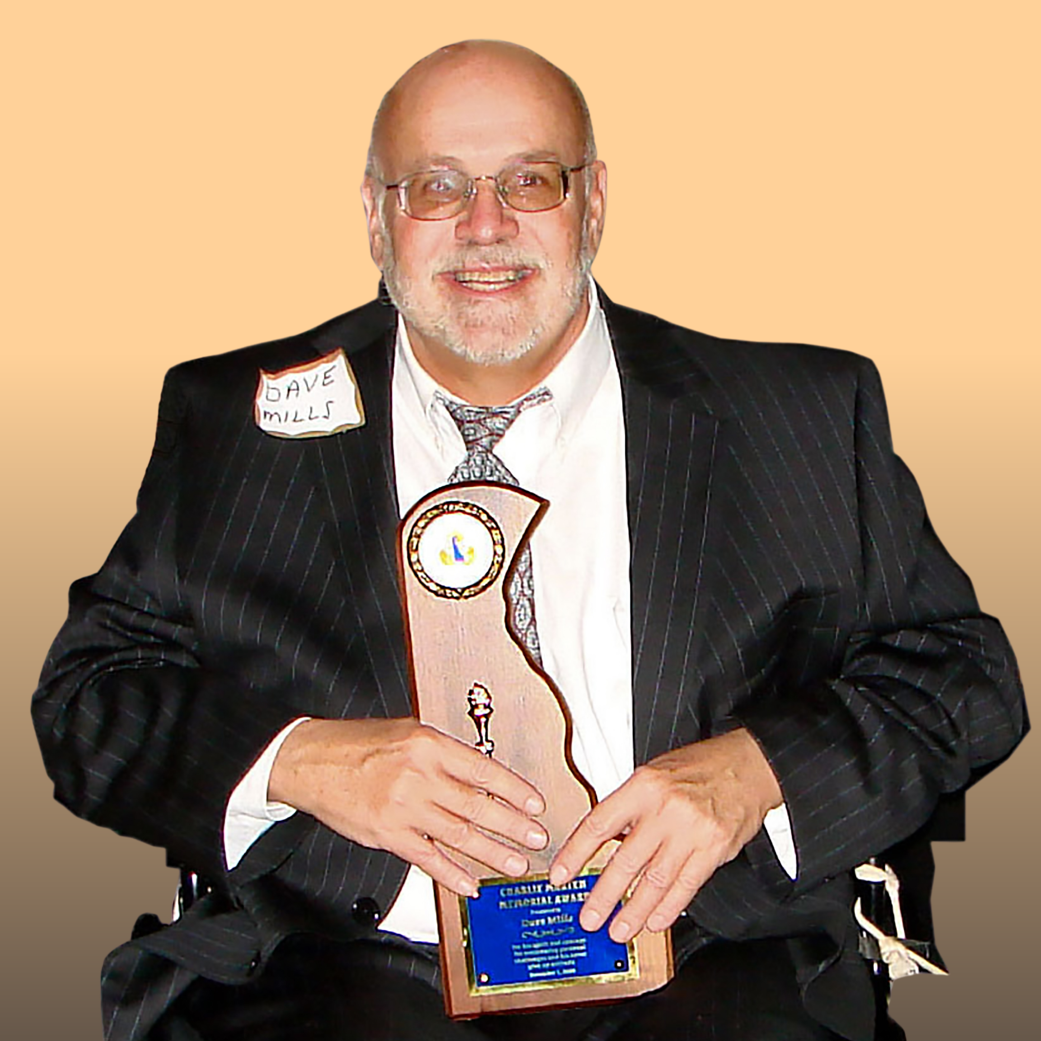 David Mills holds an award smiling