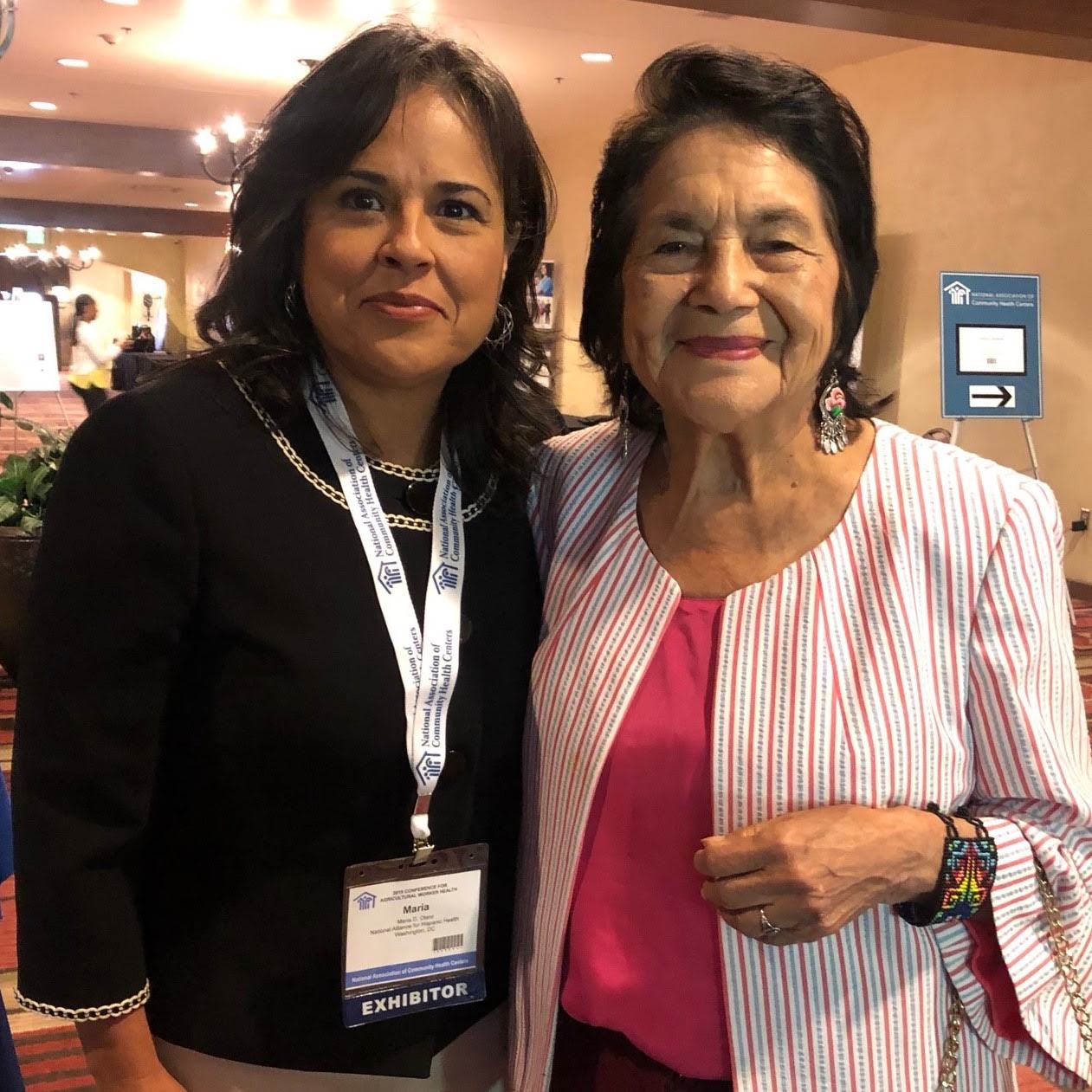 María Otero and Dolores Huerta smiling at the camera, standing next to each other. 