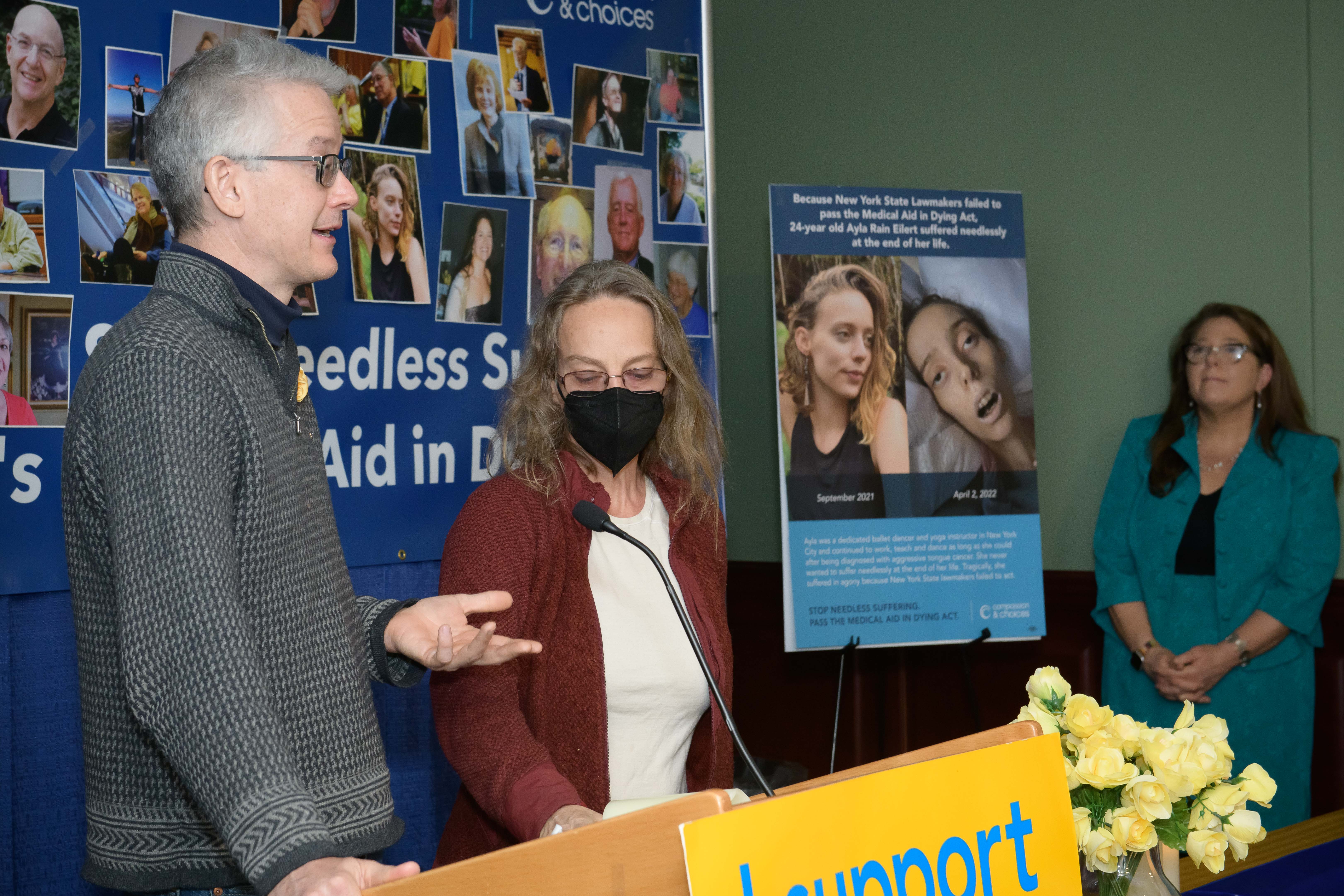 From left, Daren Eilert and Amy Eilert, addressing supporters and press in Albany. At far right, Compassion & Choices New York Senior Campaign Director Corinne Carey stands next to a poster with images of Ayla Rain Eilert, who died of tounge cancer on April 2, 2022.