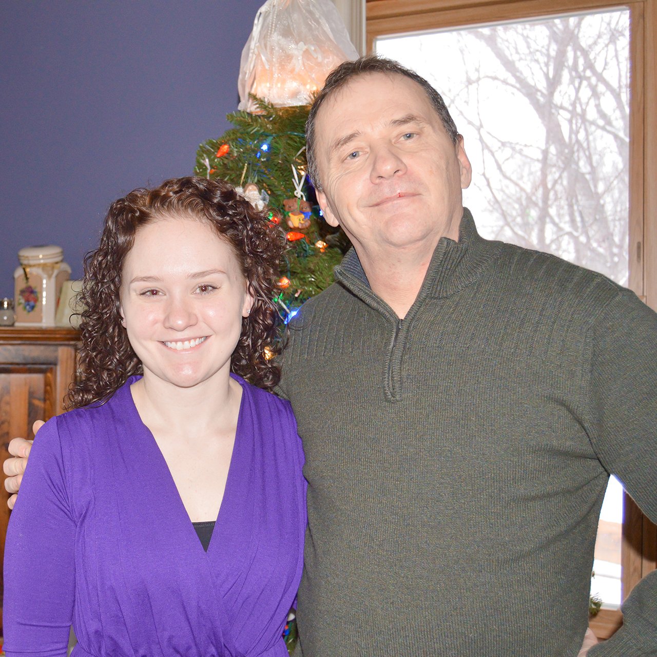Nicole Mallory and her Dad George standing in front of a Christmas Tree