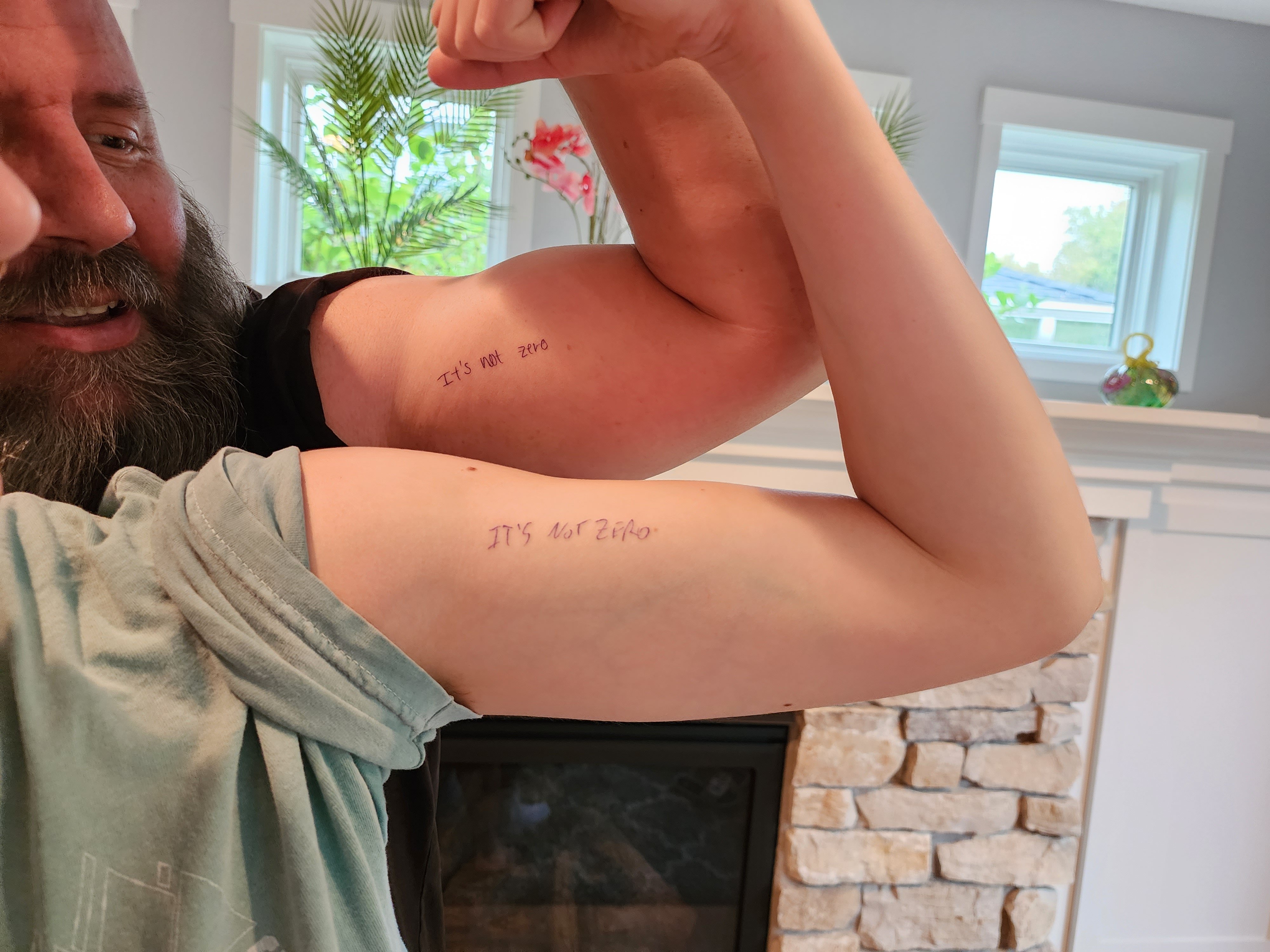 Jeff McComas and his 17 year old daughter showing their matching tattoos.