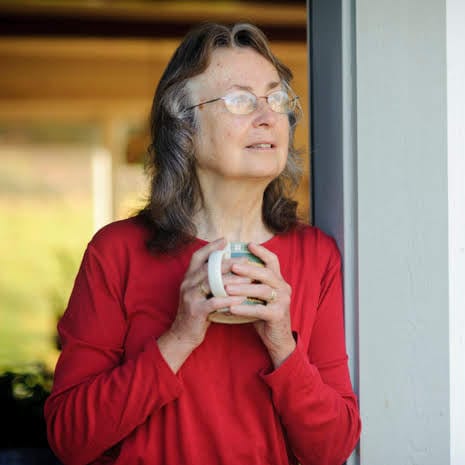 Pam Wald standing in doorway holding a coffee mug